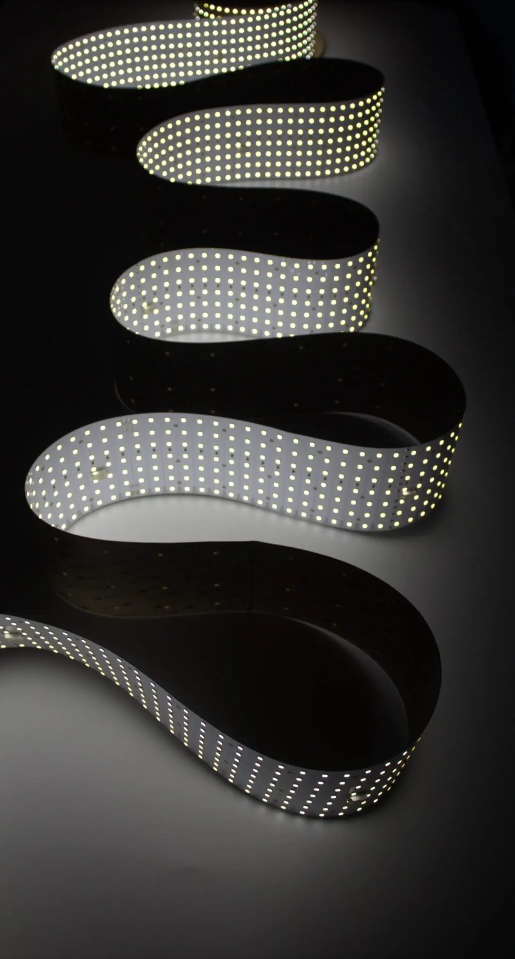 A lit, curved roll of LightWave Roll It large format backlighting solution. Shows the light curving and bending.