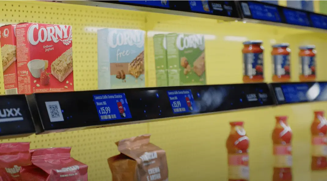 An eShelf screen on a yellow shelf with products